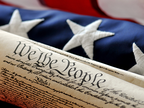 Imagen de una parte de la Constitución y la bandera estadounidense