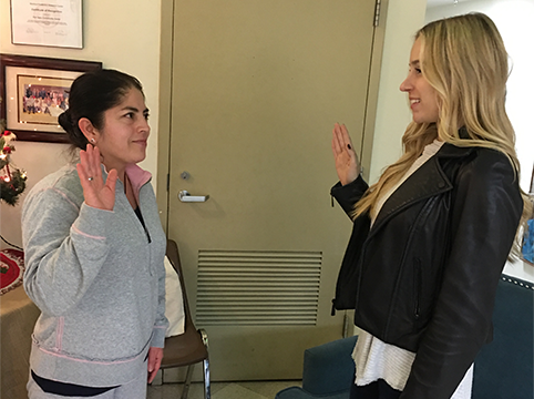 A student practicing taking the oath of allegiance with a volunteer.