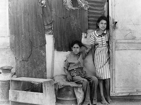 Historical photo of two Mexican children sitting on a bench.