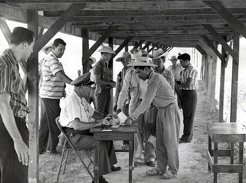 Image of Immigrant Inspector inspecting Braceros for admission, Hidalgo, Texas, 1957.