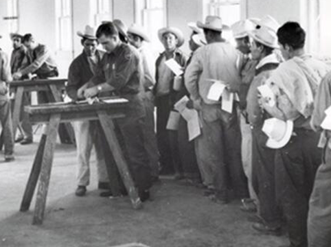 Image of Border Patrol trainees taking fingerprints of Braceros at Rio Vista Reception Center, El Paso, Texas, 1952.