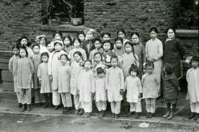 Tye Leung, second from left, back row, stands with a group of children and staff from the Presbyterian mission where she worked with Donaldina Cameron, center, a crusading anti-prostitution and anti-trafficking activist. Photo courtesy of the California History Room, California State Library, Sacramento, California.
