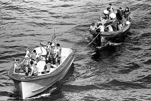 Image of A life boat from the USS BLUE RIDGE (LCC 19) tows a Vietnamese fishing boat to the amphibious command ship. 35 Vietnamese refugees were rescued 350 miles north of Cam Ranh Bay, Vietnam, after spending eight days at sea, May 15, 1984. *National Archives.